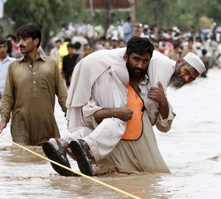 Man carries his father during a flood.