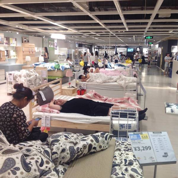 bizare things found in asia - people laying in beds at an ikea