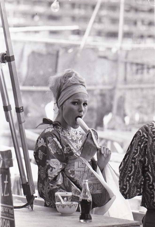 ursula andress eating a banana on the set of les tribulation d un chinois en chine
