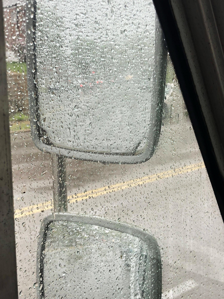 A delivery truck's mirror in the rain.