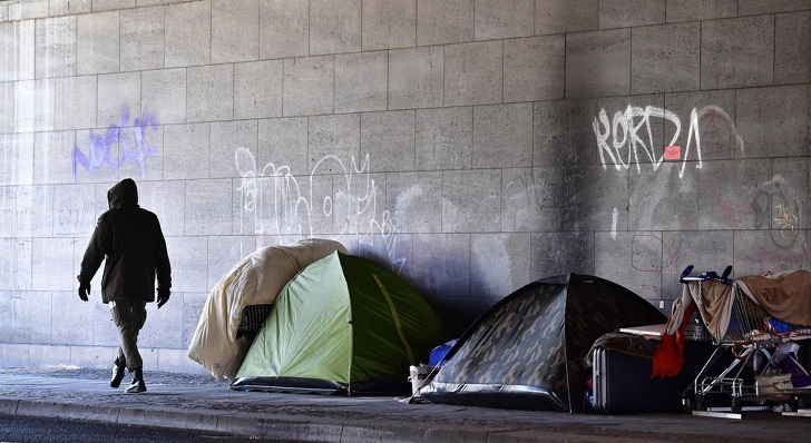 Homeless encampment under a bridge in Berlin during a severe snowstorm.