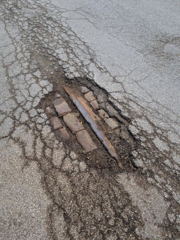 After a hard rain, a pothole opened up revealing the original brick and a train track.