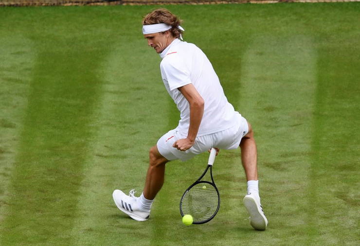 Tennis player hitting a ball between his legs