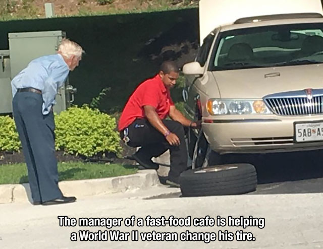chick fil a changes tire - The manager of a fastfood cafe is helping a World War Ii veteran change his tire.
