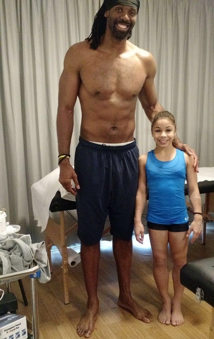 gymnast and basketball player standing side by side to compare height difference