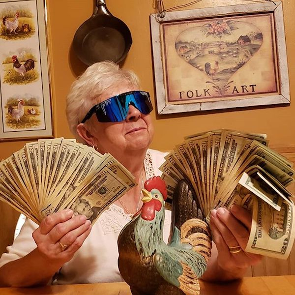 old woman holding wads of cash