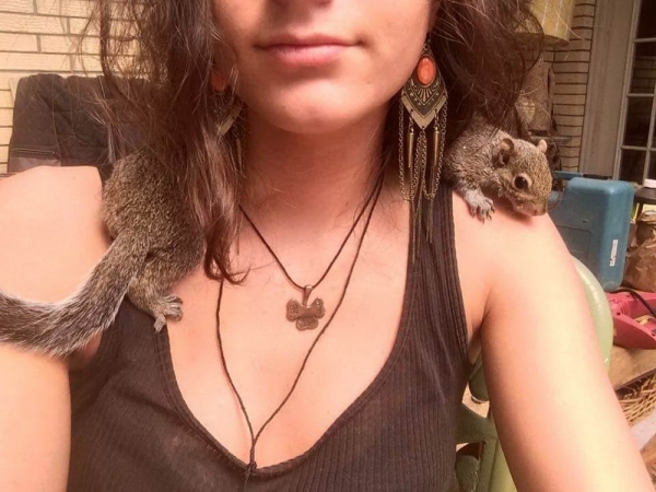 squirrel sitting on a woman's shoulders