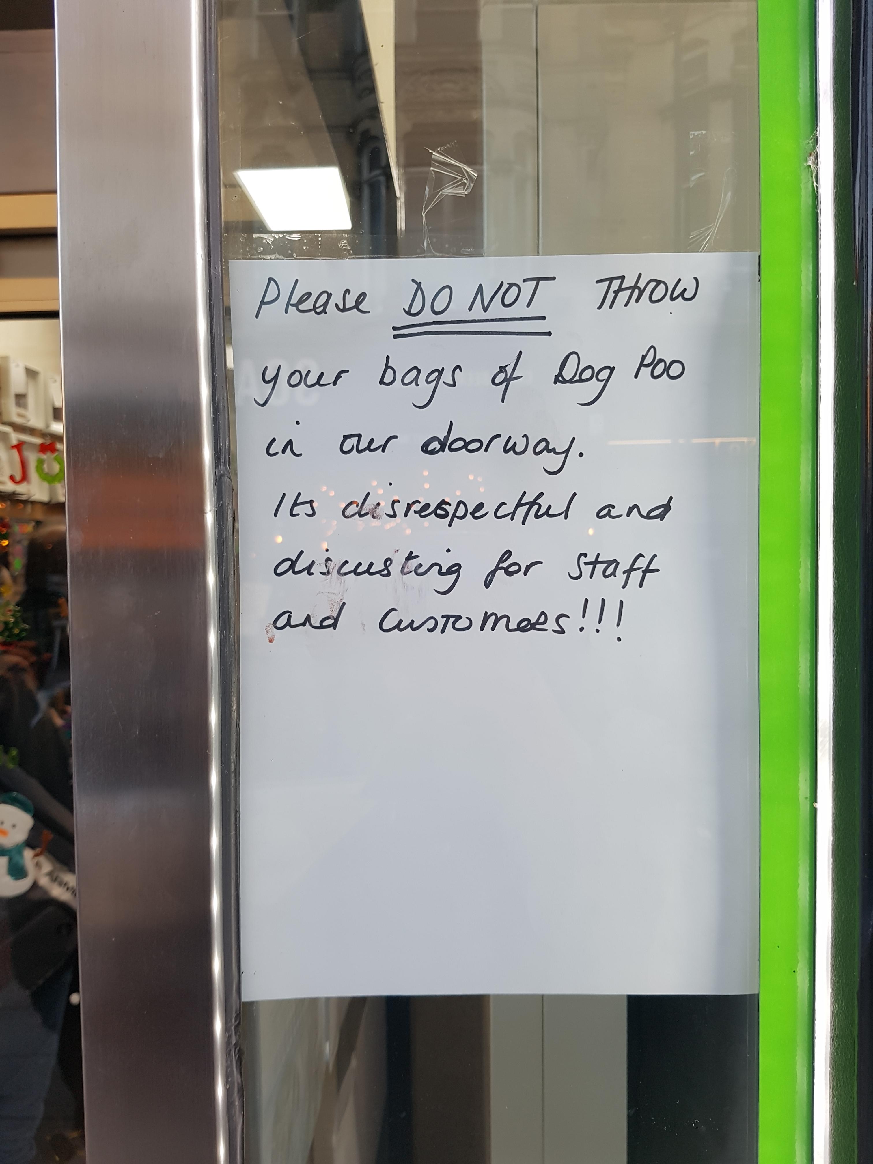 sign - Please Do Not Throw your bags of Dog Poo in our doorway. It's disrespectful and discusting for Staff and customees!!!