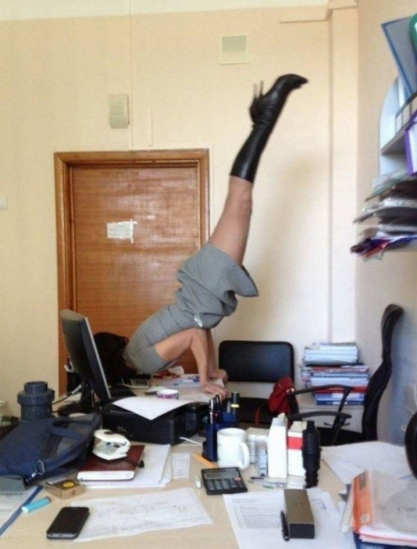 woman balancing on top of a desk