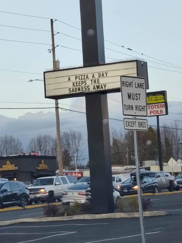 street sign - A Pizza A Day Keeps The Sadness Away Right Lane Must Right Totem Pole Excep Bikes