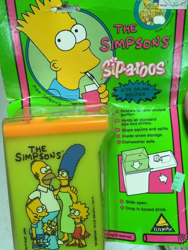 games - The Simpsons Siparoos Box Drink Holder Reseals t avo unused portion Holds all standard le box drinks Stops squirts and spills Inside straw storage Dishwasher sate The Simpsons Side open Drop in boxed drink