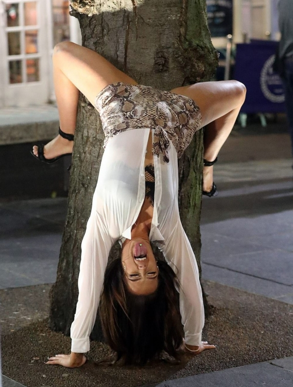 woman leaning against a tree in a weird position