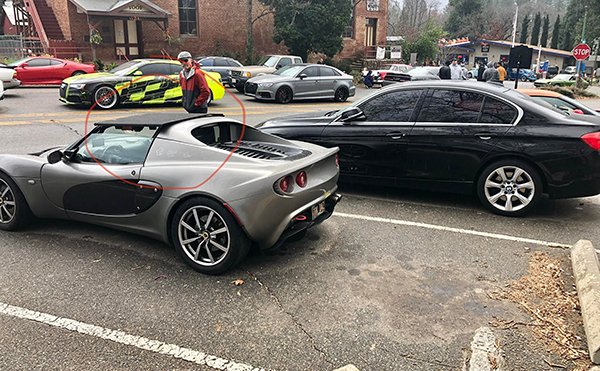 “This dude’s Lotus was stuck in the rain. Friendly BMW guy lends his trunk liner for the duration of the storm.”