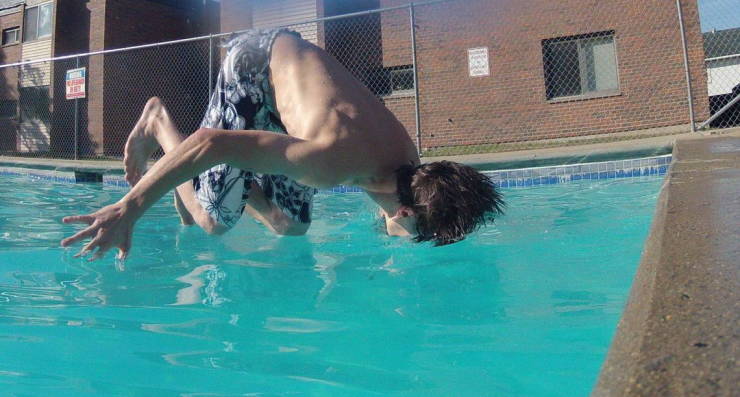 Guy falling into a pool face fiirst in a perfectly timed photo