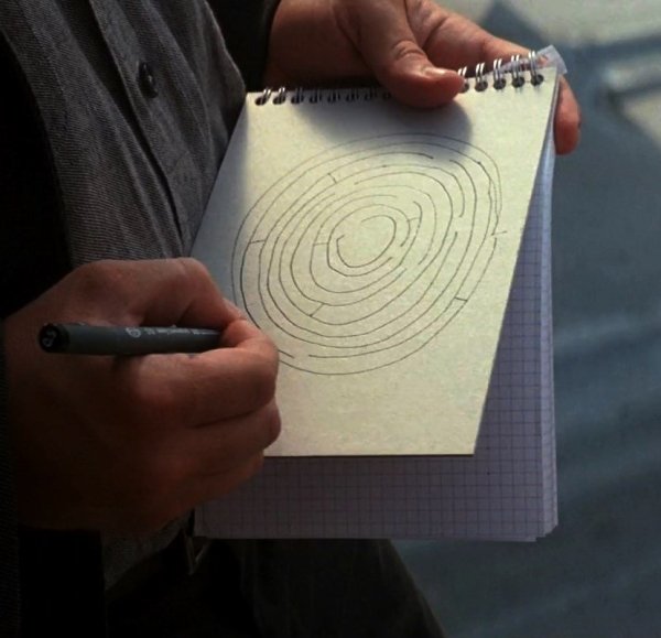 In Inception (2010), Ariadne draws the circular maze that gets her the job on the cover of the notepad. This is because the paper is gridded, which would trick a human into drawing a square or rectangular shape.
