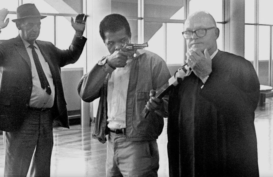 James McClain points a revolver and a sawed-off shotgun that is taped to the neck of Judge Harold J. Haley at the Marin County courthouse, August 7, 1970