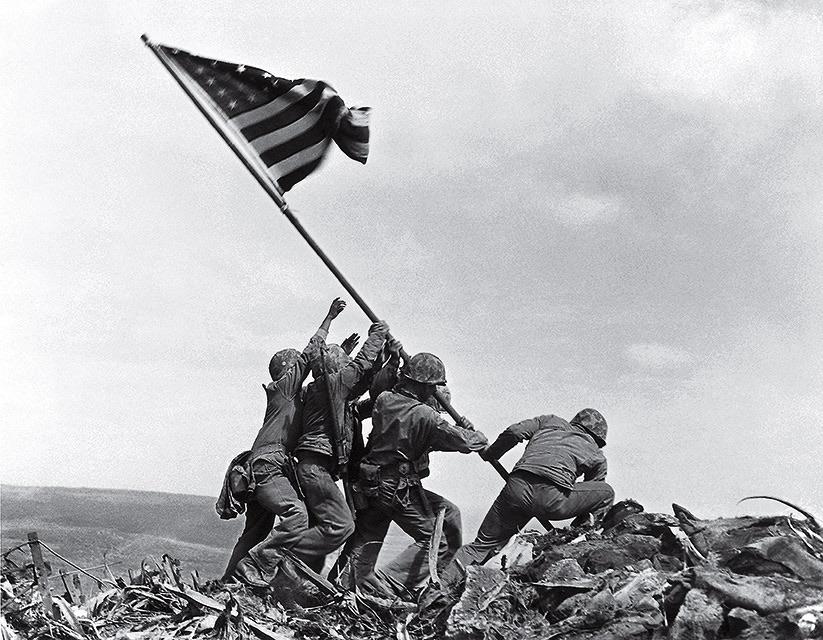 U.S. Marines of the 28th Regiment, 5th Division, raise the American flag atop Mt. Suribachi, Iwo Jima on Feb. 23, 1945.