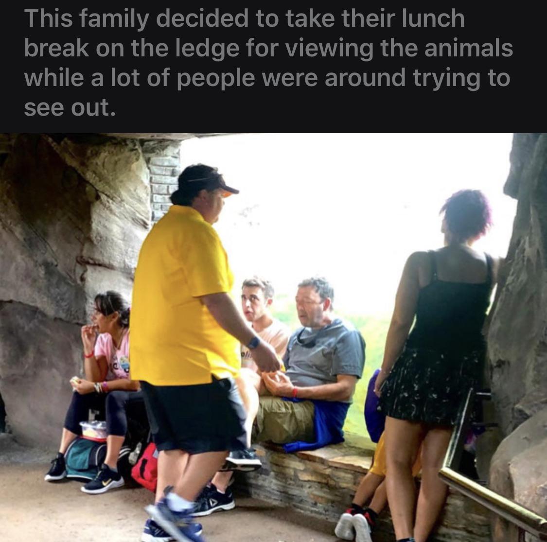 community - This family decided to take their lunch break on the ledge for viewing the animals while a lot of people were around trying to see out.