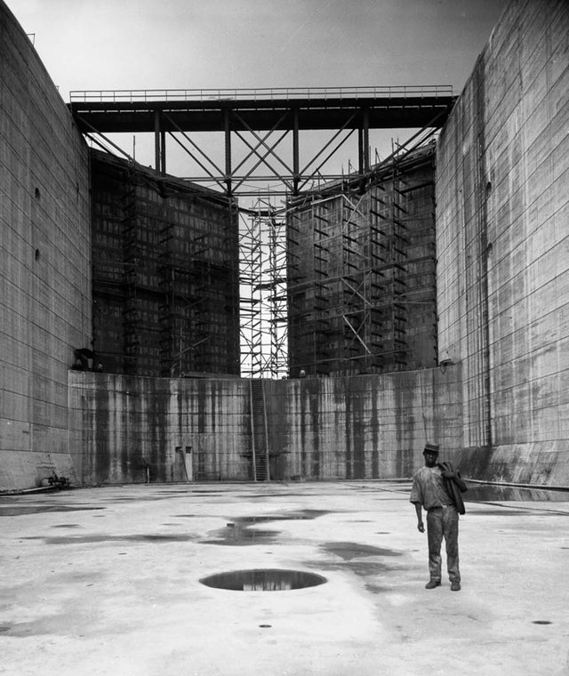 Panama Canal Construction - A worker stands in one of the canal locks, 1912