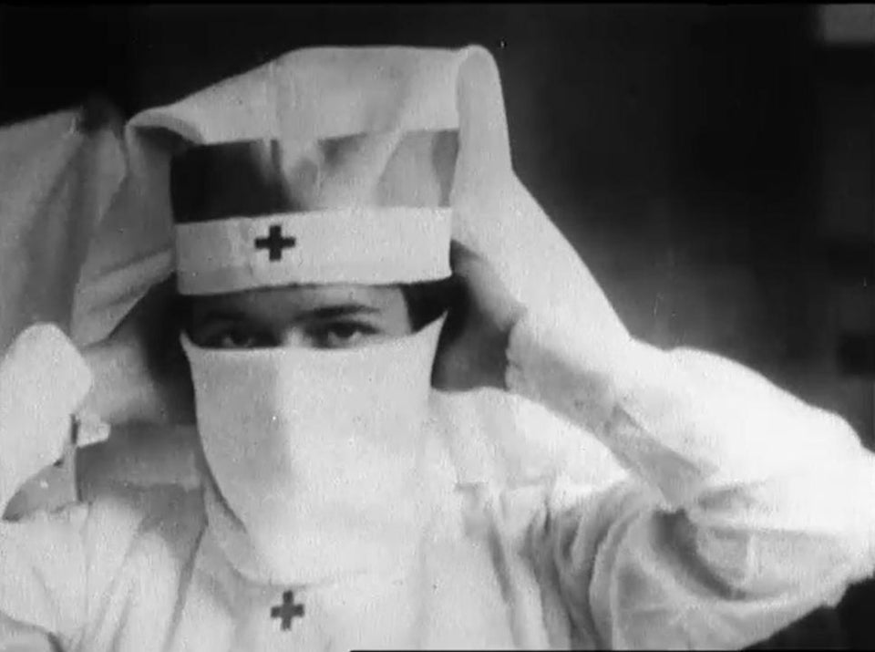 A Red Cross Nurse Demonstrates how to put on a Mask during the Spanish Flu Pandemic, Boston, 1918