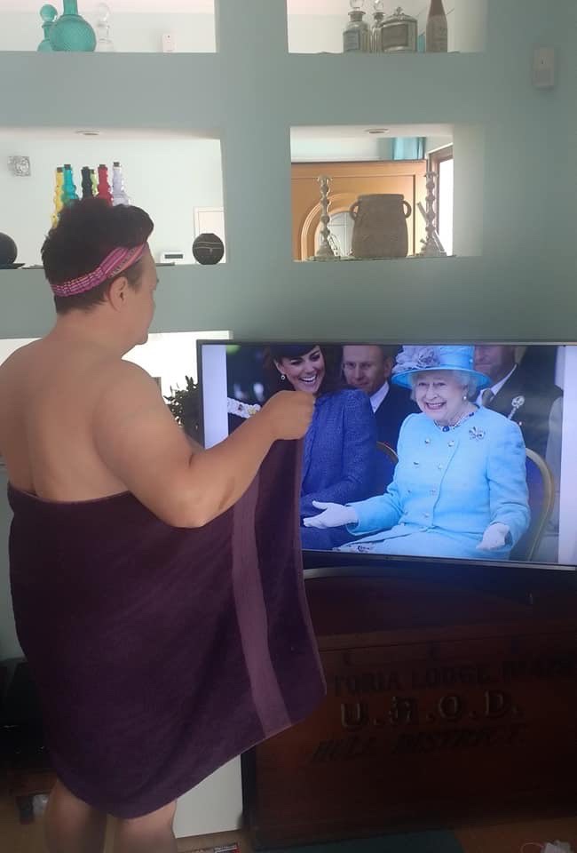 Woman opening her towel to the Queen on tv