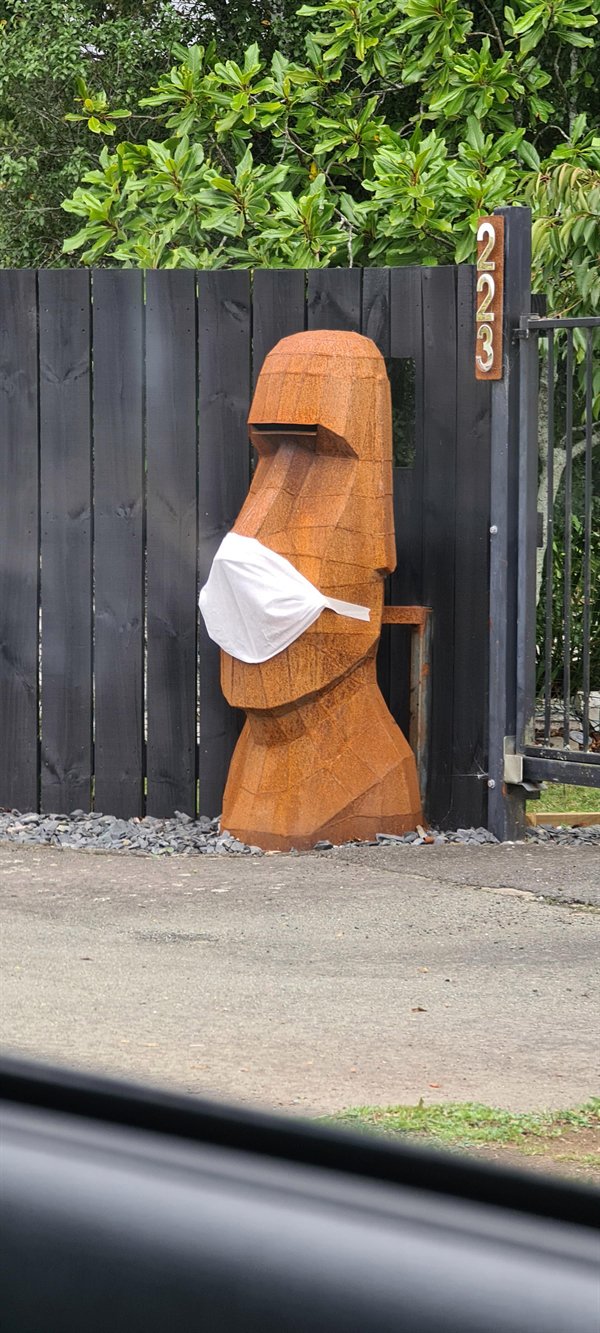 wooden statue wearing surgical mask