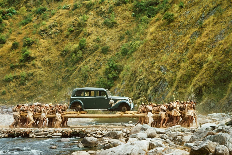 ”Nepal workers carrying cars on the rocky, hilly trail from Kathmandu to India as a trade-in on a shiny American model. 60 men, moving to the rhythm of a chant, balance it on long poles.” Nepal, 1949.