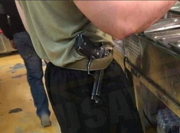 gun hanging on man's belt