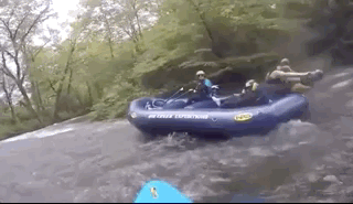 people fighting in a raft while white water rafting