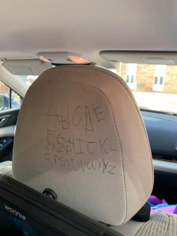 car headrest with alphabet scrawled on the back in pen ink