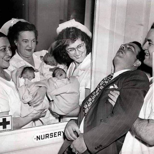 nurses showing a set of newly born triplets to a surprised father in a new york city hospital 1946 - Nursery