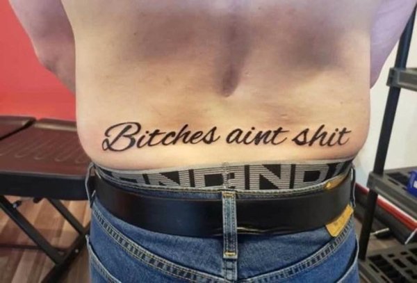 man's lower back tattoo - Bitches aint shit
