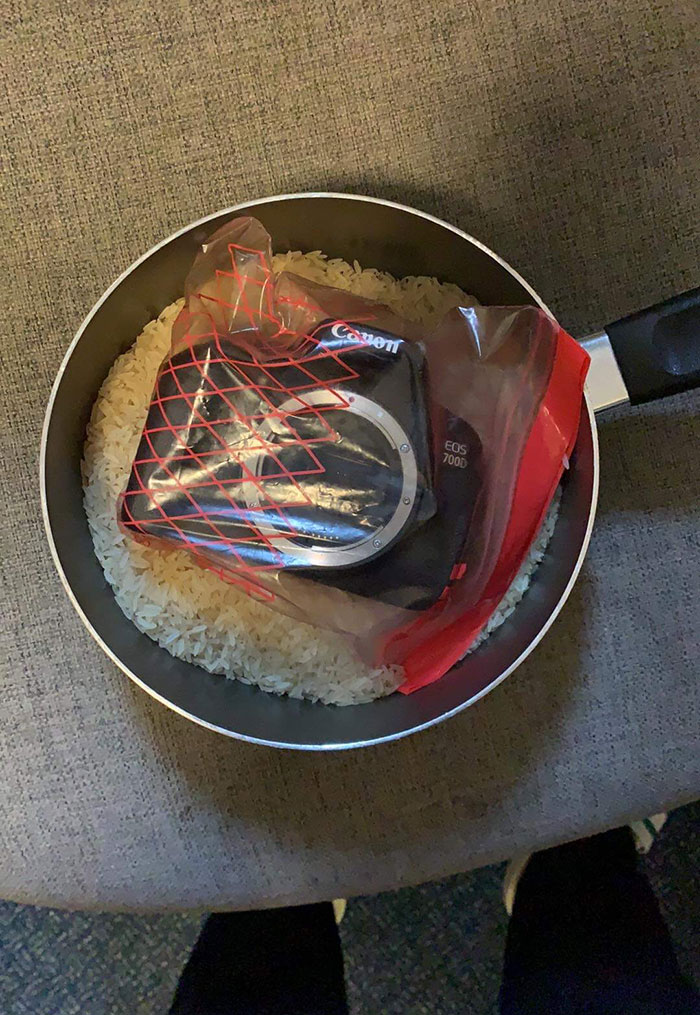 digital camera inside a zip top bag inside a pot full of rice