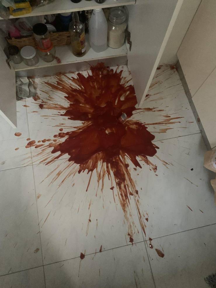 entire bottle of tomato sauce broken and spilled on the kitchen floor
