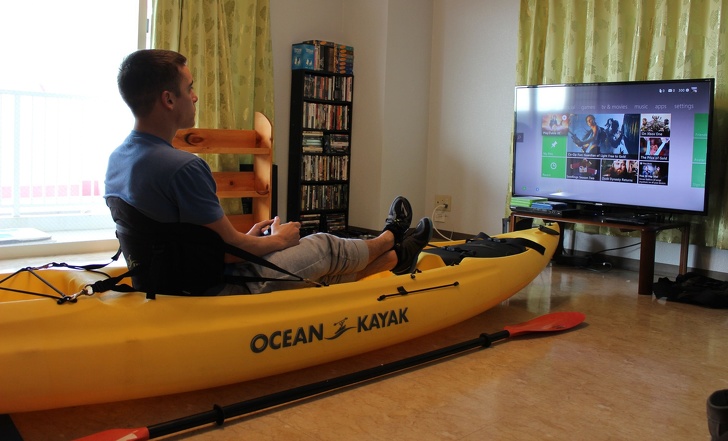 genius problem solvers - guy using a kayak instead of a couch in his home to play video games