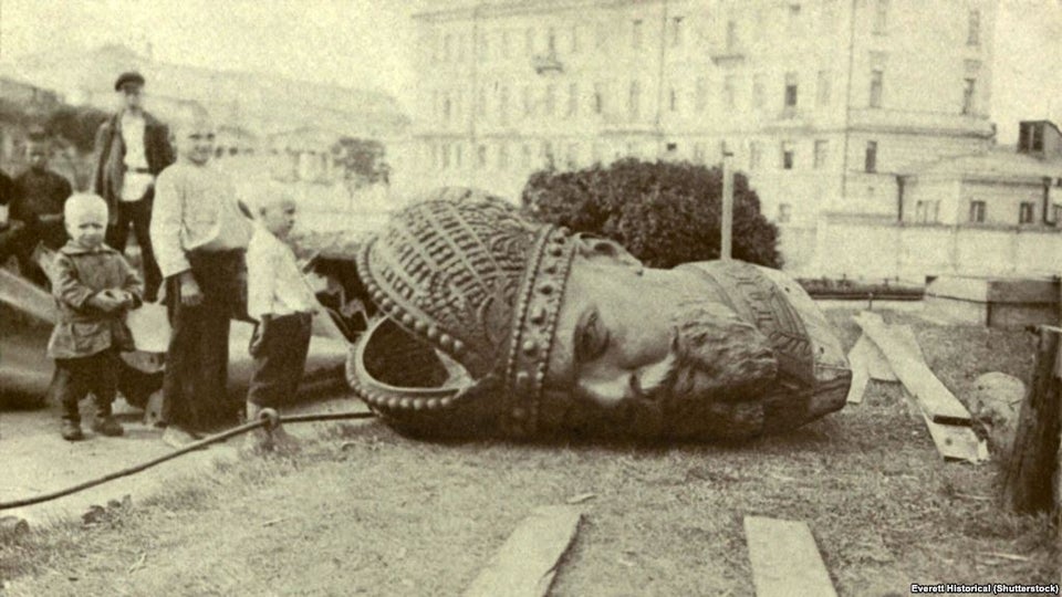 Following the Bolshevik revolution, children stand alongside the broken bronze head of Czar Alexander III in Moscow 1918.