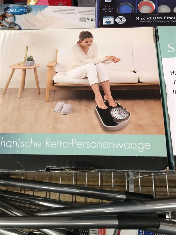 woman sitting on a couch using a scale wrong