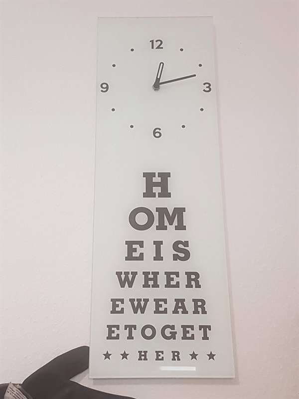 weird clock with motivational phrase on it looks like eye doctor chart