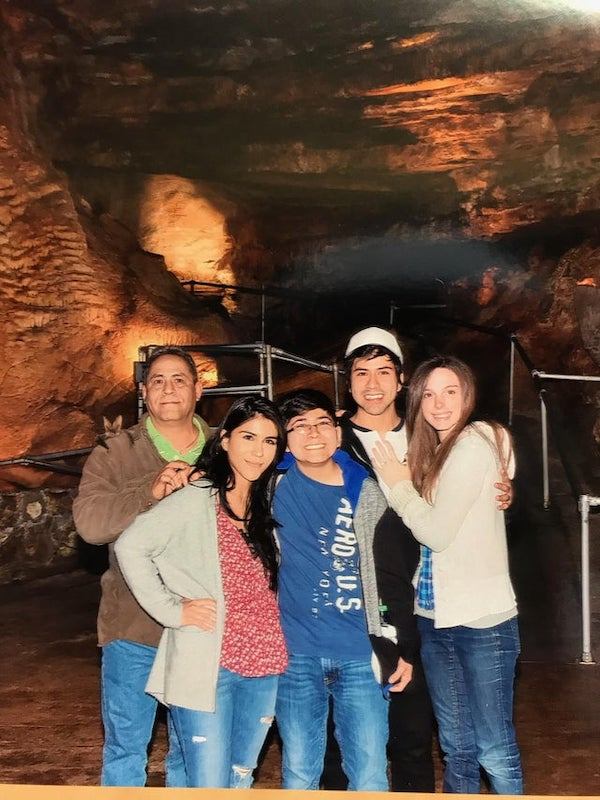 family in cave with bat on the dad's shoulder