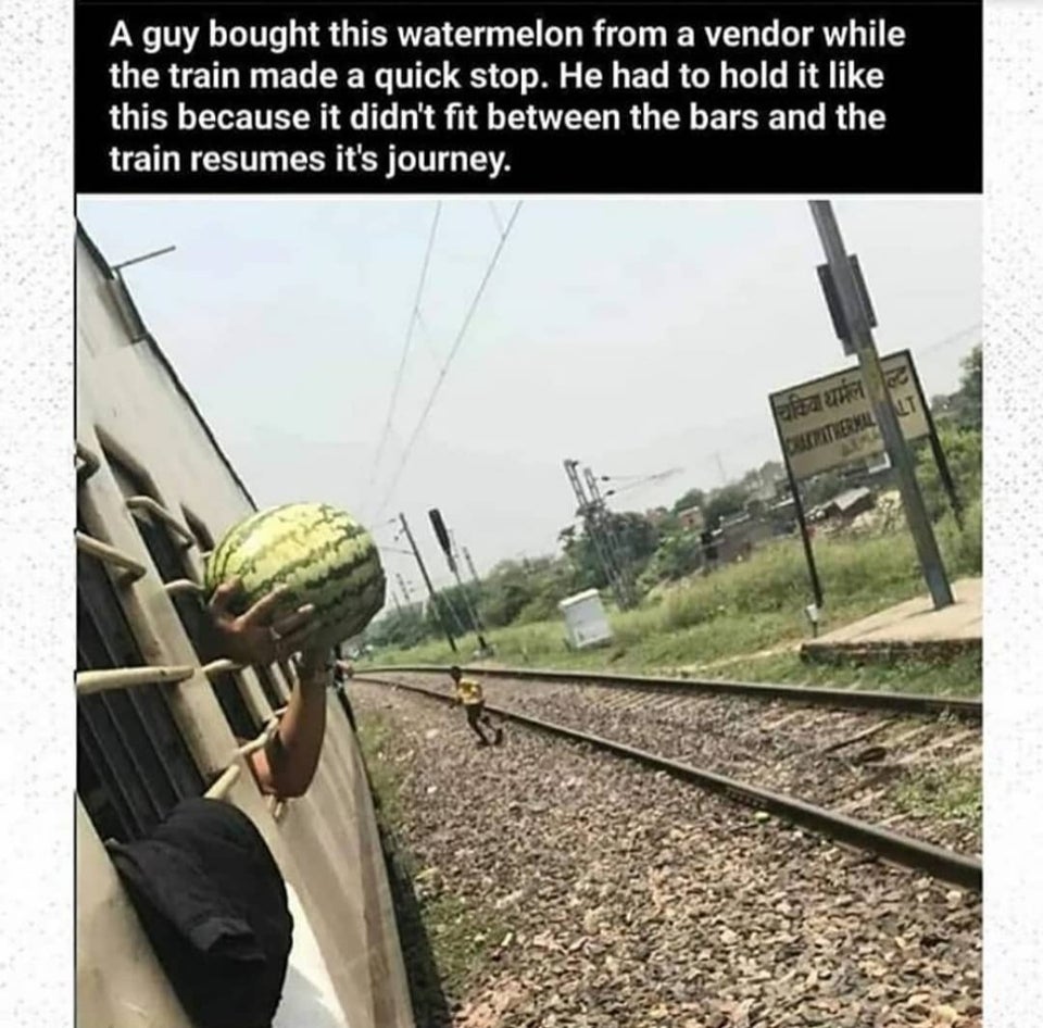 A guy bought this watermelon from a vendor while the train made a quick stop. He had to hold it this because it didn't fit between the bars and the train resumes its journey.