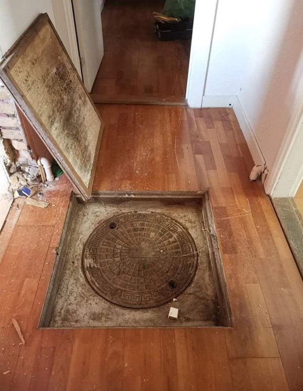 wooden floor with old rusty metal sewer cap hidden under it