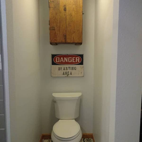 Danger Blasting area sign above toilet