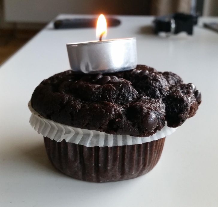 chocolate cupcake with metal tea candle stuck on top