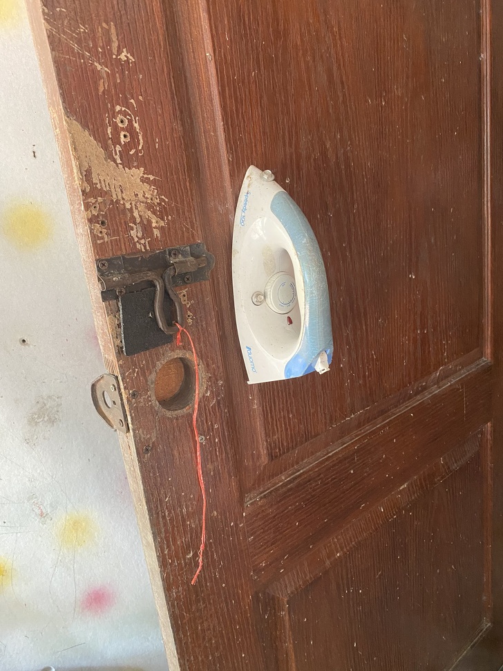 door with laundry iron nailed to it as handle
