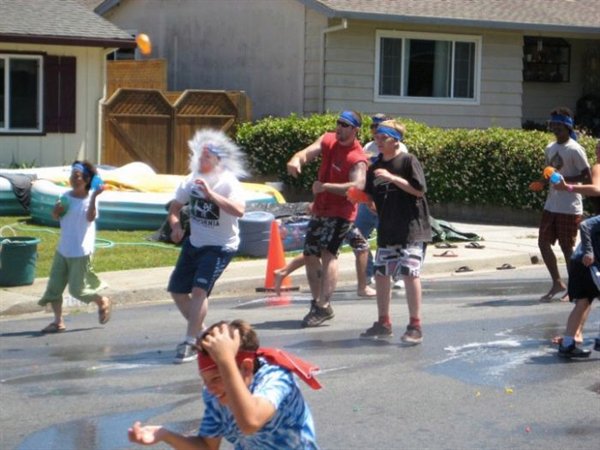 kid getting hit in the face with a water balloon