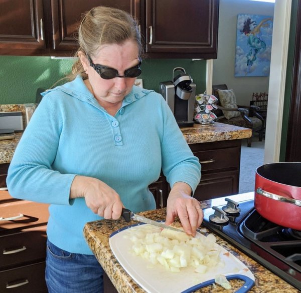 woman wears swim goggles while cutting onions