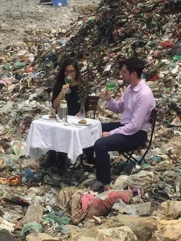 sad couple eating dinner in landfill