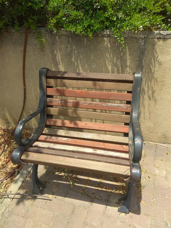 a single seat one person wooden park bench
