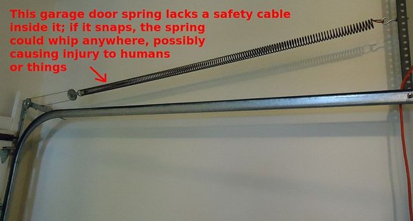 garage door spring safety cable - This garage door spring lacks a safety cable inside it; if it snaps, the spring could whip anywhere, possibly causing injury to humans or things