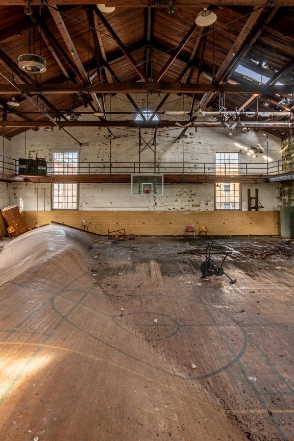 old abandoned basketball court with warped floor boards